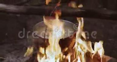 古老的复古营地平底<strong>锅开水</strong>为汤准备在森林的火。 夏季晚上的火焰篝火